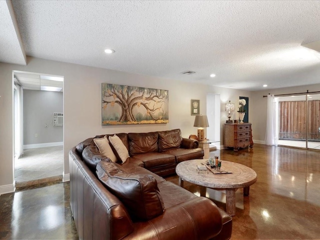 living room with a wall mounted air conditioner and a textured ceiling