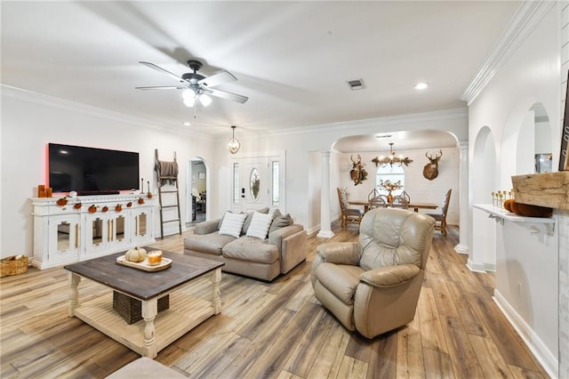 living room featuring light wood-type flooring, ceiling fan with notable chandelier, and crown molding