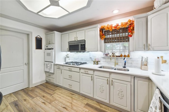 kitchen with white cabinetry, light wood-type flooring, appliances with stainless steel finishes, and sink