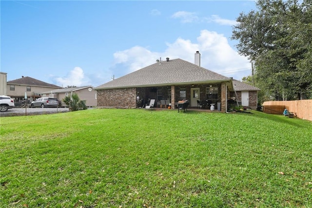 rear view of house featuring a yard and a patio area