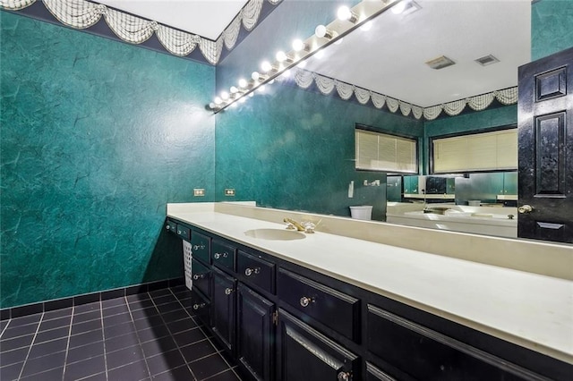 bathroom with toilet, vanity, and tile patterned flooring