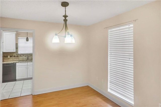 unfurnished dining area featuring light wood-type flooring and sink