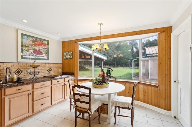 dining room featuring wood walls, light tile patterned floors, and sink