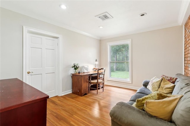 office area with light wood-type flooring, a brick fireplace, and crown molding