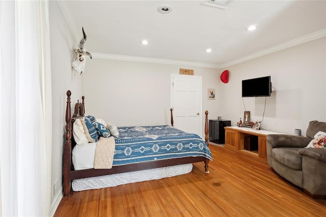 bedroom with crown molding, light wood-style flooring, and recessed lighting