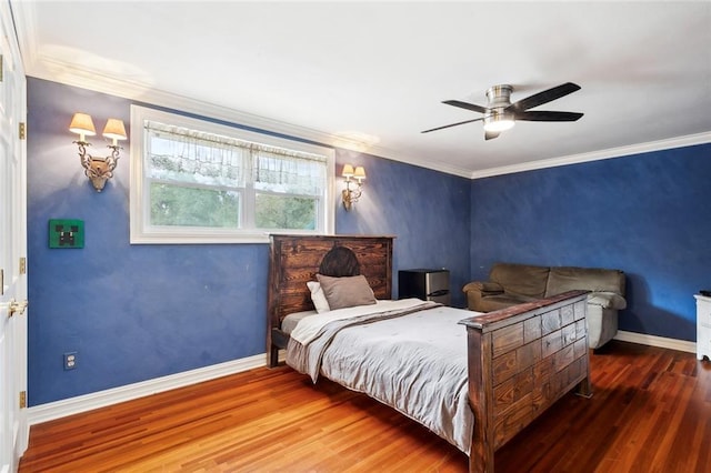 bedroom with baseboards, ornamental molding, wood finished floors, and a ceiling fan