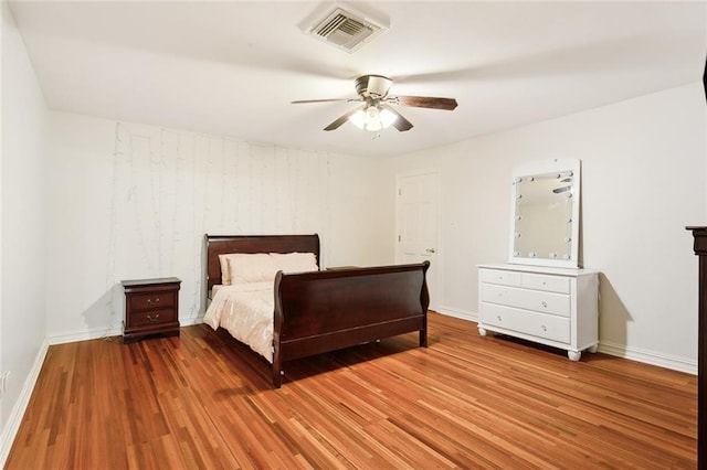 unfurnished bedroom with a ceiling fan, wood finished floors, baseboards, and visible vents