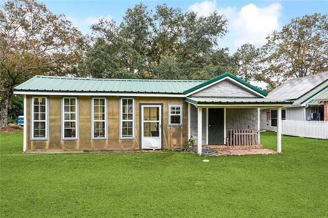 rear view of house with a lawn and metal roof
