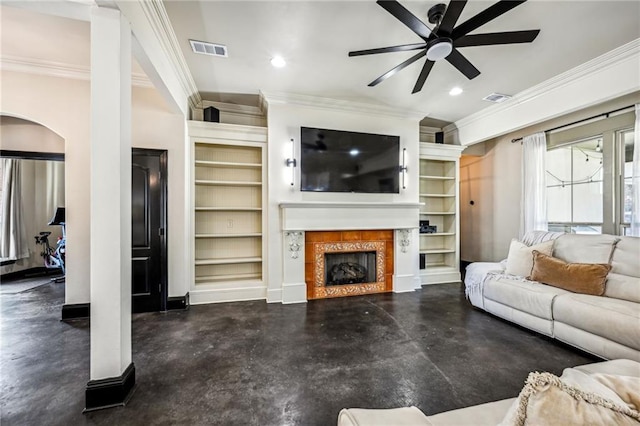 living room featuring built in shelves, ceiling fan, crown molding, and a fireplace