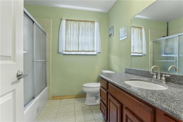 full bathroom featuring vanity, a wealth of natural light, tile patterned floors, and toilet