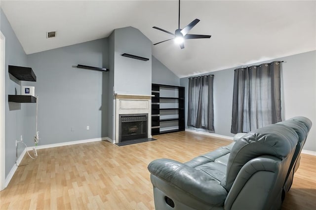 living room featuring high vaulted ceiling, light hardwood / wood-style floors, and ceiling fan