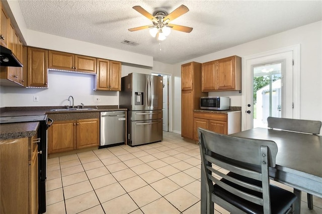 kitchen with appliances with stainless steel finishes, a textured ceiling, light tile patterned floors, sink, and ceiling fan