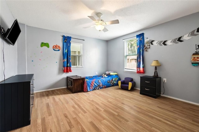 bedroom featuring a textured ceiling, ceiling fan, and light hardwood / wood-style flooring