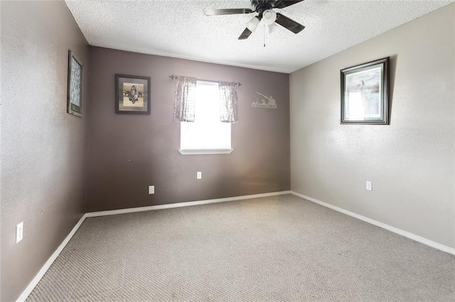 carpeted spare room featuring ceiling fan and a textured ceiling