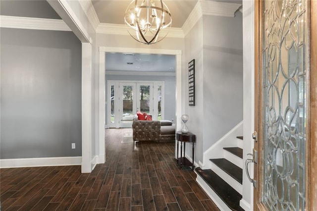 entrance foyer with dark wood-type flooring, french doors, a notable chandelier, and ornamental molding