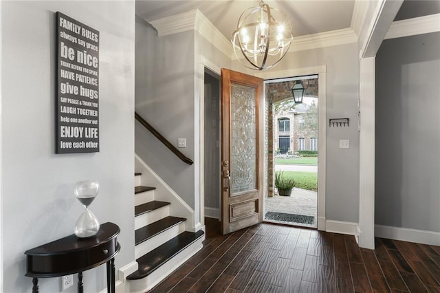 entryway featuring ornamental molding, dark wood-type flooring, and an inviting chandelier