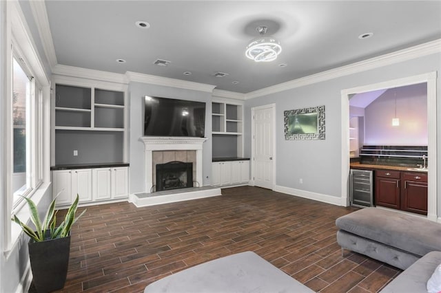 living room featuring a fireplace, dark wood-type flooring, a healthy amount of sunlight, and wine cooler