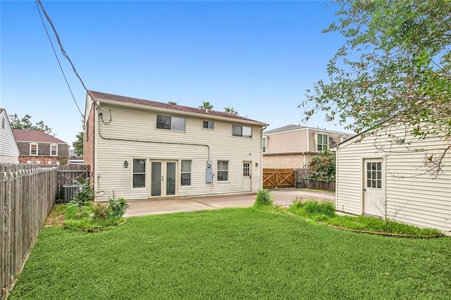 rear view of property featuring a patio, central AC, and a yard