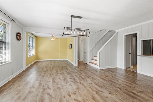 unfurnished living room featuring ceiling fan, ornamental molding, and light hardwood / wood-style flooring