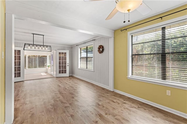 interior space featuring light hardwood / wood-style floors, crown molding, wooden walls, and french doors