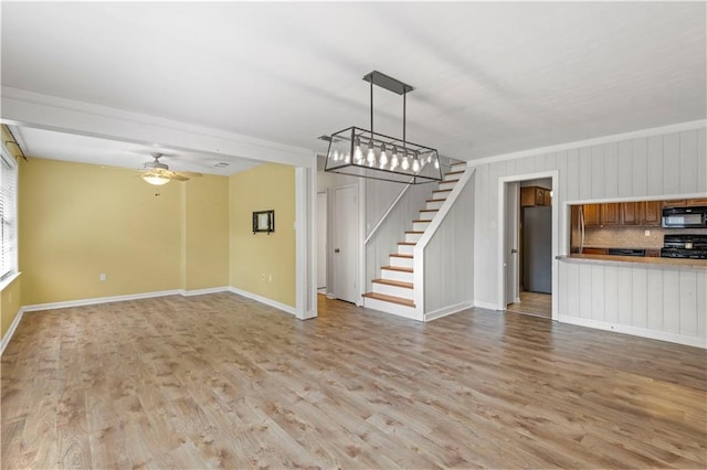 unfurnished living room featuring light wood-type flooring, ceiling fan, and crown molding