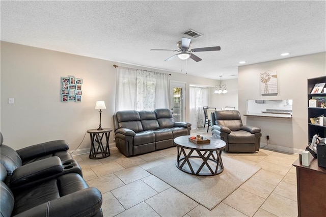 tiled living room with a textured ceiling and ceiling fan with notable chandelier