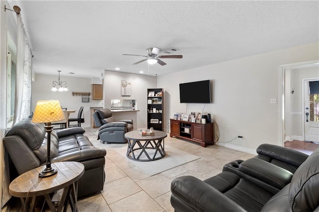 living room with ceiling fan with notable chandelier and a textured ceiling