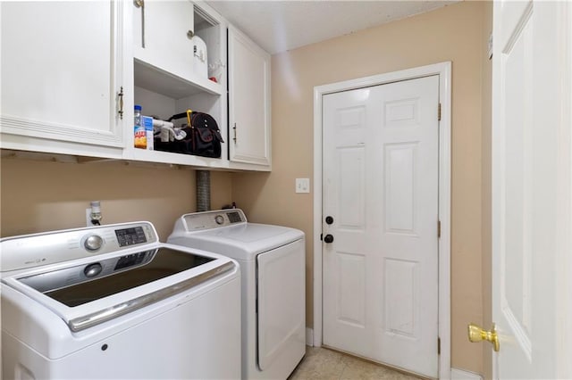 clothes washing area featuring cabinets, independent washer and dryer, and light tile patterned floors