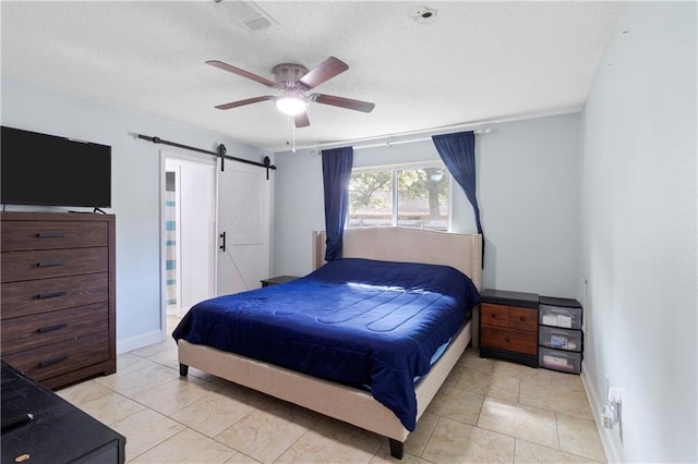 bedroom featuring a barn door, ceiling fan, and light tile patterned floors