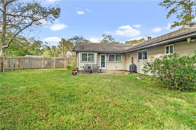 back of property with a lawn and a patio