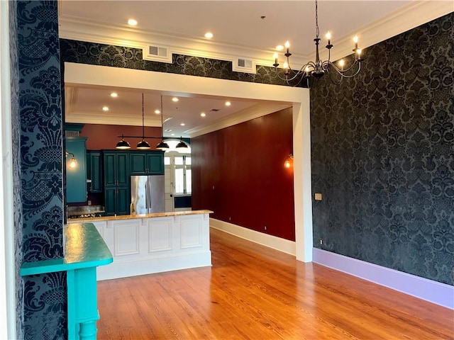 kitchen featuring stainless steel refrigerator, crown molding, and light wood-type flooring