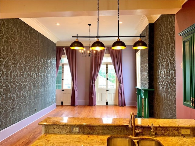 interior space featuring hardwood / wood-style floors, ornamental molding, decorative light fixtures, and sink