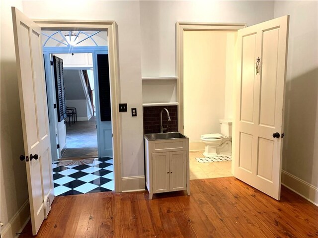 1225 Bourbon St Unit B, New Orleans, LA 70116 - bathroom with a sink, toilet, wood finished floors, and baseboards