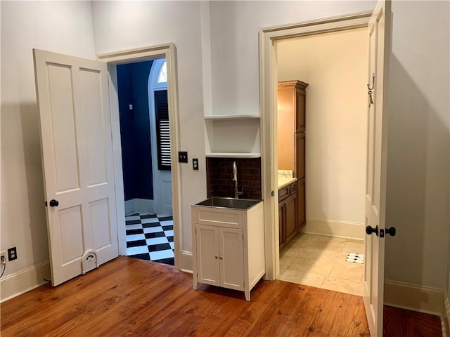 hallway featuring light wood-type flooring and sink