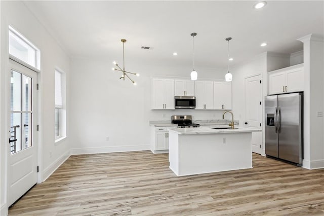 kitchen with light hardwood / wood-style floors, appliances with stainless steel finishes, an island with sink, and a healthy amount of sunlight