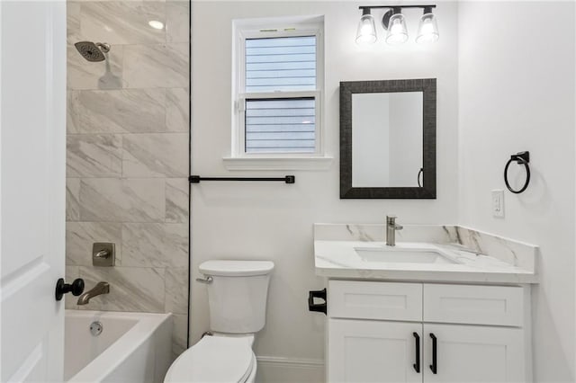 full bathroom with vanity, tiled shower / bath combo, and toilet