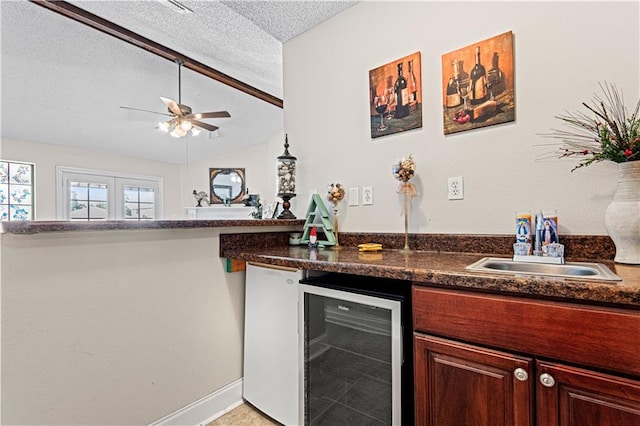 bar with wine cooler, dark stone countertops, ceiling fan, a textured ceiling, and vaulted ceiling