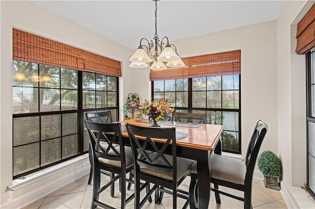 dining space featuring a notable chandelier and light tile patterned floors