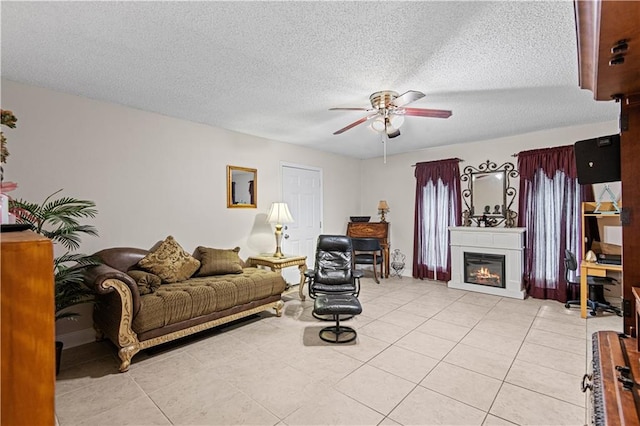 living room featuring a textured ceiling, ceiling fan, and light tile patterned floors