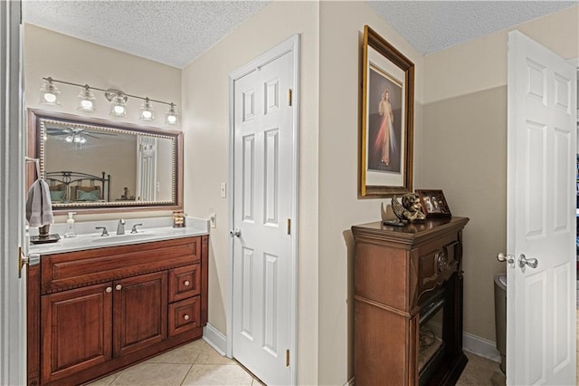 bathroom featuring toilet, vanity, a textured ceiling, and tile patterned floors