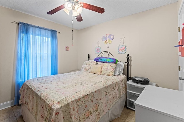 bedroom featuring a textured ceiling, tile patterned flooring, and ceiling fan