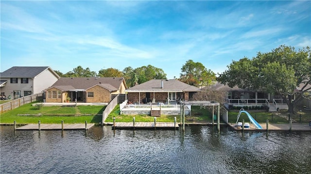 view of dock featuring a water view and a yard