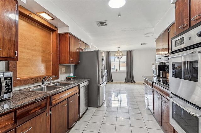 kitchen with hanging light fixtures, sink, appliances with stainless steel finishes, a notable chandelier, and light tile patterned flooring