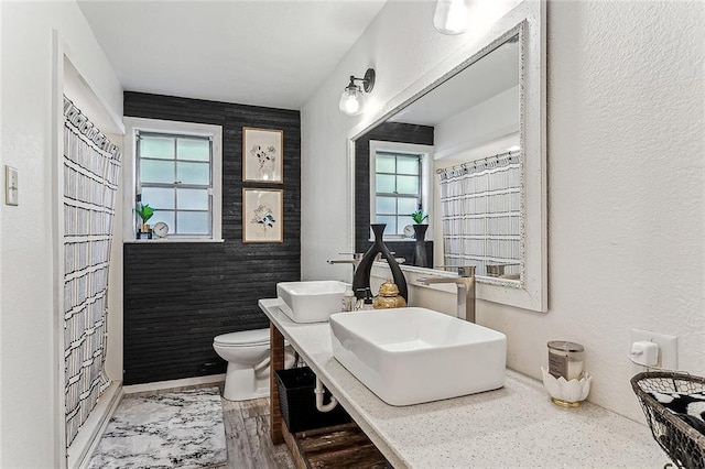 bathroom featuring a shower with curtain, sink, hardwood / wood-style floors, and toilet