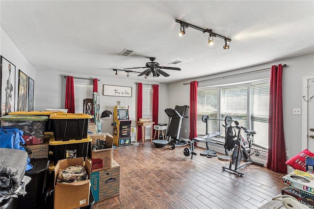 workout room with wood-type flooring, track lighting, and ceiling fan