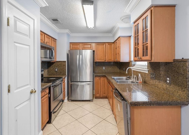 1714 Kings Row, Slidell, LA 70461 - kitchen featuring appliances with stainless steel finishes, a sink, light tile patterned floors, a textured ceiling, and brown cabinets
