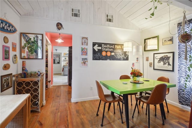 dining space with hardwood / wood-style flooring, wood ceiling, and high vaulted ceiling