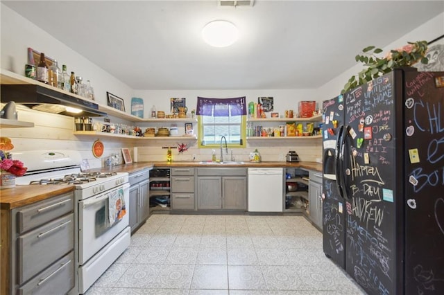 kitchen with wooden counters, sink, white appliances, and light tile patterned flooring