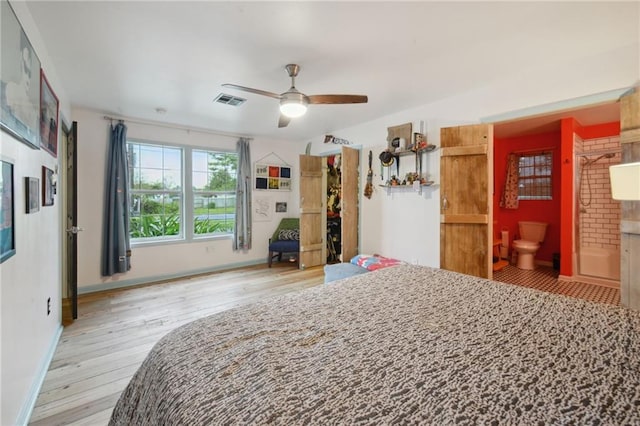 bedroom with light hardwood / wood-style flooring, ceiling fan, and connected bathroom