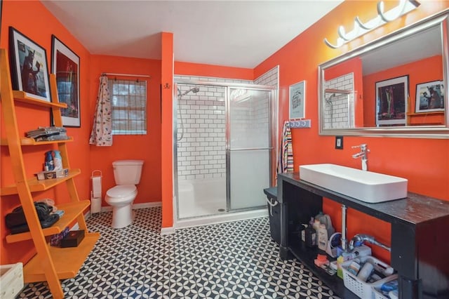 bathroom with a shower with shower door, vanity, and toilet